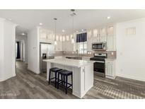 Modern kitchen with island, stainless steel appliances, and white cabinets at 305 S Val Vista Dr # 71, Mesa, AZ 85204