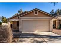 Tan house with a two-car garage and desert landscaping at 34717 N Picket Post Dr, Queen Creek, AZ 85142