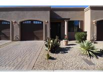 Tan stucco exterior with two-car garage and desert landscaping at 4241 N Pebble Creek Pkwy # 13, Goodyear, AZ 85395