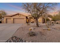 Desert landscape surrounds this one-story home with a three-car garage at 7126 E Bobwhite Way, Scottsdale, AZ 85266