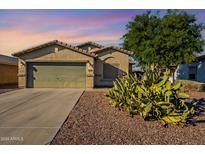 Single-story house with a two-car garage and desert landscaping at 7334 S Morning Dew Ln, Buckeye, AZ 85326