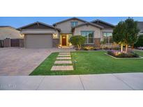 Beautiful home with landscaped yard, stone accents, and a three-car garage at 9343 W Cashman Dr, Peoria, AZ 85383