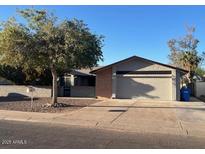 Ranch style home with a two-car garage and mature landscaping at 10138 W Highland Ave, Phoenix, AZ 85037