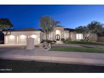 Stunning curb appeal featuring a two-story home with a three-car garage and manicured lawn at 12079 E Cortez Dr, Scottsdale, AZ 85259