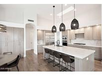 Spacious kitchen boasts a large island, stainless steel appliances, and modern pendant lighting at 12079 E Cortez Dr, Scottsdale, AZ 85259