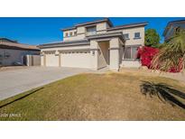 Two-story house with a three-car garage and landscaped front yard at 14754 W Amelia Ave, Goodyear, AZ 85395