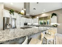 Bright kitchen showcases granite counters, sleek stainless appliances, overhead lighting, and eat-in island with stool seating at 210 E Bergamot Ln, Queen Creek, AZ 85140