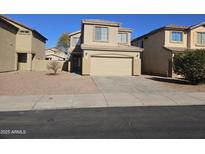 Two-story house with tan exterior, two-car garage, and landscaping at 11410 W Cocopah St, Avondale, AZ 85323