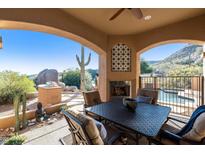 Covered patio with fireplace, seating area, and mountain views at 14597 E Corrine Dr, Scottsdale, AZ 85259