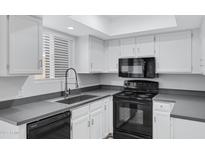 Well-equipped kitchen with white cabinets and black appliances at 17242 N 16Th Dr # 9, Phoenix, AZ 85023