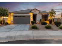 One-story home with gray garage door, landscaping, and a welcoming front porch at 18280 N Piccolo Dr, Maricopa, AZ 85138