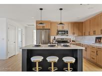 Modern kitchen with island, stainless steel appliances, and light wood cabinets at 4129 E Eugie Ave, Phoenix, AZ 85032