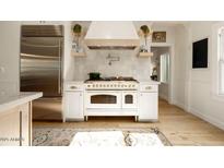 Modern kitchen with white cabinets, a farmhouse sink, and stainless steel appliances at 6740 N 7Th St, Phoenix, AZ 85014