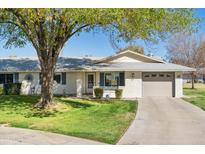 Single-story home with a landscaped lawn and attached garage at 9518 W Shasta Dr, Sun City, AZ 85351