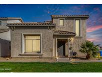 Two-story stucco home with landscaped lawn and walkway at 8478 W Lewis Ave, Phoenix, AZ 85037