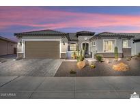Beautiful desert home exterior with a 3-car garage and landscaped front yard at 20210 N Wagner Wash Dr, Buckeye, AZ 85396