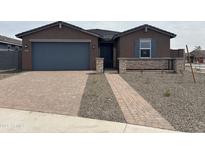 Charming single-story home with a brick driveway and a well-manicured front yard at 4807 N 177Th Ln, Goodyear, AZ 85395
