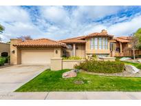 Tan two-story house with a tile roof, landscaping, and a two-car garage at 5418 E Piping Rock Rd, Scottsdale, AZ 85254