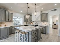 Spacious kitchen featuring gray cabinetry, white countertops, and pendant lighting at 12015 S Tuzigoot Dr, Phoenix, AZ 85044