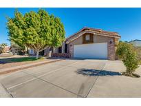 Two-story house with a large tree and driveway at 12465 N 71St Ave, Peoria, AZ 85381