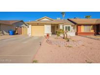 Single-story home with a yellow garage door and landscaped front yard at 1758 E Sandra Ter, Phoenix, AZ 85022