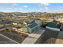 Aerial view of a single-story house with a detached garage, desert landscaping, and mountain views at 338 W Fairfield St, San Tan Valley, AZ 85143