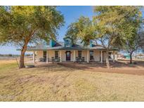 Two-story house with wraparound porch and landscaped yard at 42516 N Suburban Ave, San Tan Valley, AZ 85140