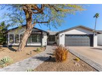 Updated single story home with gray accents and a landscaped front yard at 4356 E Coconino St, Phoenix, AZ 85044