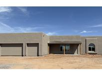 Modern home featuring a stucco exterior, covered porch, arched window, and convenient two-car garage at 30039 N 209Th Ave, Wittmann, AZ 85361