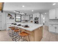 Modern kitchen with white cabinets, quartz countertops, and stainless steel appliances at 6613 W Sweetwater Ave, Glendale, AZ 85304