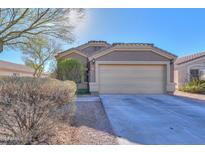 One-story house with a beige exterior, two-car garage, and well-manicured landscaping at 1643 E Bishop Dr, Casa Grande, AZ 85122