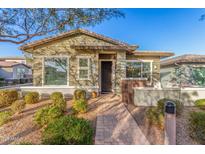 Single-story home with green siding, brick accents, and landscaped front yard at 20771 W Windsor Blvd, Buckeye, AZ 85396