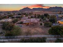 Aerial view of a beautiful home with a pool and large backyard, set against a mountain backdrop at 20918 E Orchard Ln, Queen Creek, AZ 85142