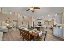 Bright dining area features a rustic wood table set, flowing into the living room and kitchen for open-concept living at 3462 E Riopelle Ave, Gilbert, AZ 85298