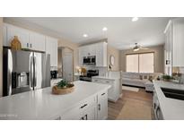 Modern kitchen with white cabinetry, stainless steel appliances, and a quartz island perfect for entertaining and everyday living at 3462 E Riopelle Ave, Gilbert, AZ 85298