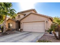 Tan house with two-car garage and desert landscaping at 14995 W Desert Hills Dr, Surprise, AZ 85379