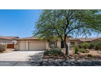Charming home exterior with a three car garage, desert landscaping, and beautiful mature shade tree at 4119 S Las Villa Way, Gold Canyon, AZ 85118