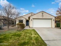 Single-story home with a two-car garage and well-manicured lawn at 41876 W Corvalis Ln, Maricopa, AZ 85138