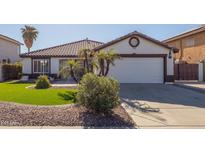 House exterior features a single-story design, white walls, and a brown tile roof at 10873 W Carlota Ln, Peoria, AZ 85373