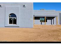 Modern exterior of a newly built house with custom arched window and tan exterior walls at 24235 N 194Th Ave, Surprise, AZ 85387