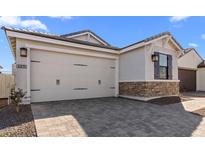 View of the home's garage with attractive stone accents and a paved driveway at 4419 N 203Rd Ave, Buckeye, AZ 85396