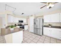 Bright kitchen featuring white cabinets, stainless steel appliances, and tiled flooring at 659 S Dodge St, Gilbert, AZ 85233