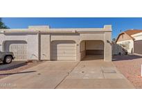 Tan stucco house with a two-car garage and a paved driveway at 1920 S Plaza Dr # 26, Apache Junction, AZ 85120