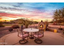 Desert landscape with fire pit and seating area at sunset at 5418 S Emerald Desert Dr, Gold Canyon, AZ 85118