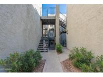Well-lit entryway with stairs leading to unit and landscaping at 8020 E Thomas Rd # 215, Scottsdale, AZ 85251