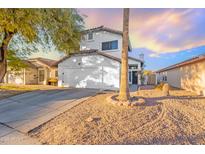 Two-story house with a white exterior, a two-car garage, and a landscaped front yard at 11618 W Olive Dr, Avondale, AZ 85392