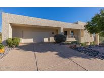 Desert landscape surrounds this modern home with a large garage and covered entry at 17022 E Player Ct, Fountain Hills, AZ 85268