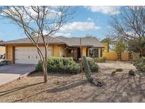 Charming single-story home featuring a two-car garage and xeriscaped front yard with desert landscaping and mature cacti at 1801 E Aire Libre Ave, Phoenix, AZ 85022