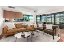 Modern living room features a leather sofa, two armchairs, and a coffee table at 4808 N 24Th St # 921, Phoenix, AZ 85016