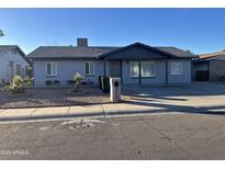 Gray single story home with landscaped front yard and a covered porch at 7217 W Claremont St, Glendale, AZ 85303